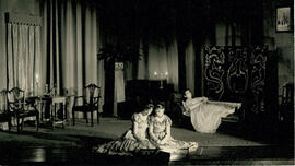 Unnamed play K, three cast members draped door table and chairs, couch and screen, [no date].