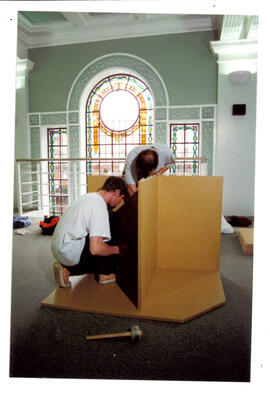 Carrel building in front of stained glass.