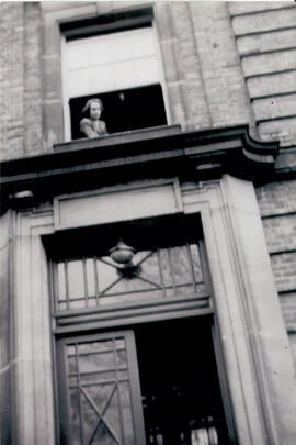 Kathleen Dickenson at the window of her room above the entrance of Macaulay Hall 1947
