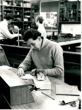 Working on electric motor, taking notes.