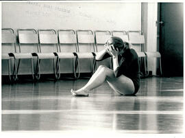 Female student sitting on floor.