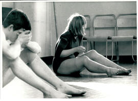 Male and female students sitting on floor.