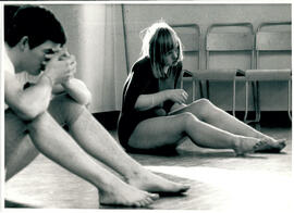 Male and female students sitting on floor.