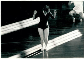 Two figures in movement, diagonal light across floor.