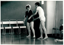 Two figures and four chairs.